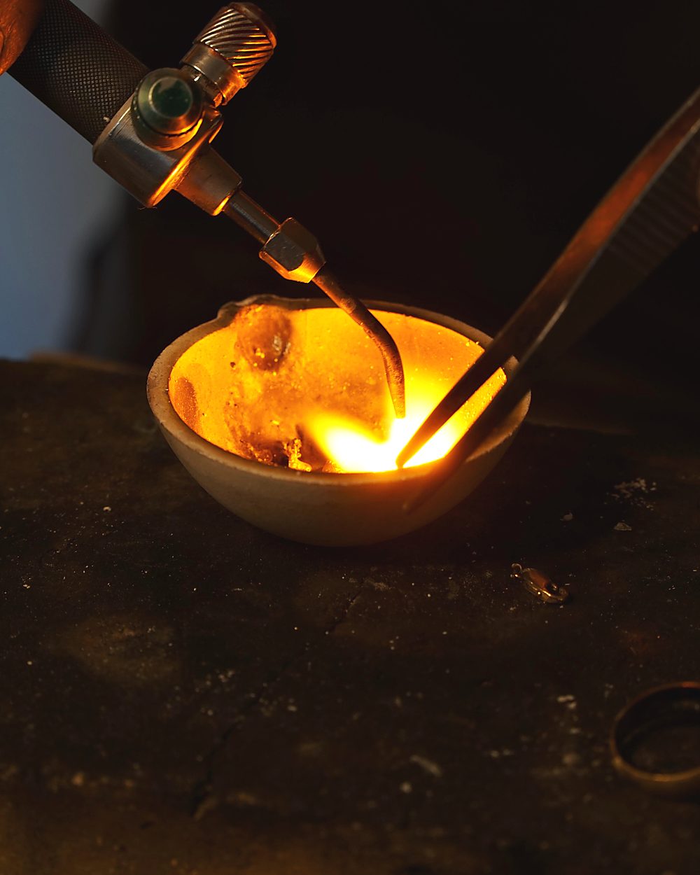 Gold schmilzt im Tiegel unter der Flamme