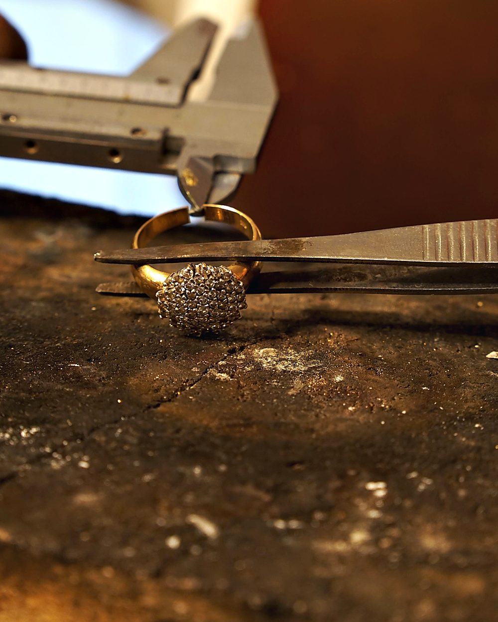 Ein Ring mit Steinen wird mit dem Messschieber vermessen